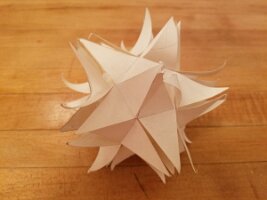 Small stellated dodecahedron made from slotted pentagrams without glue, steam damaged